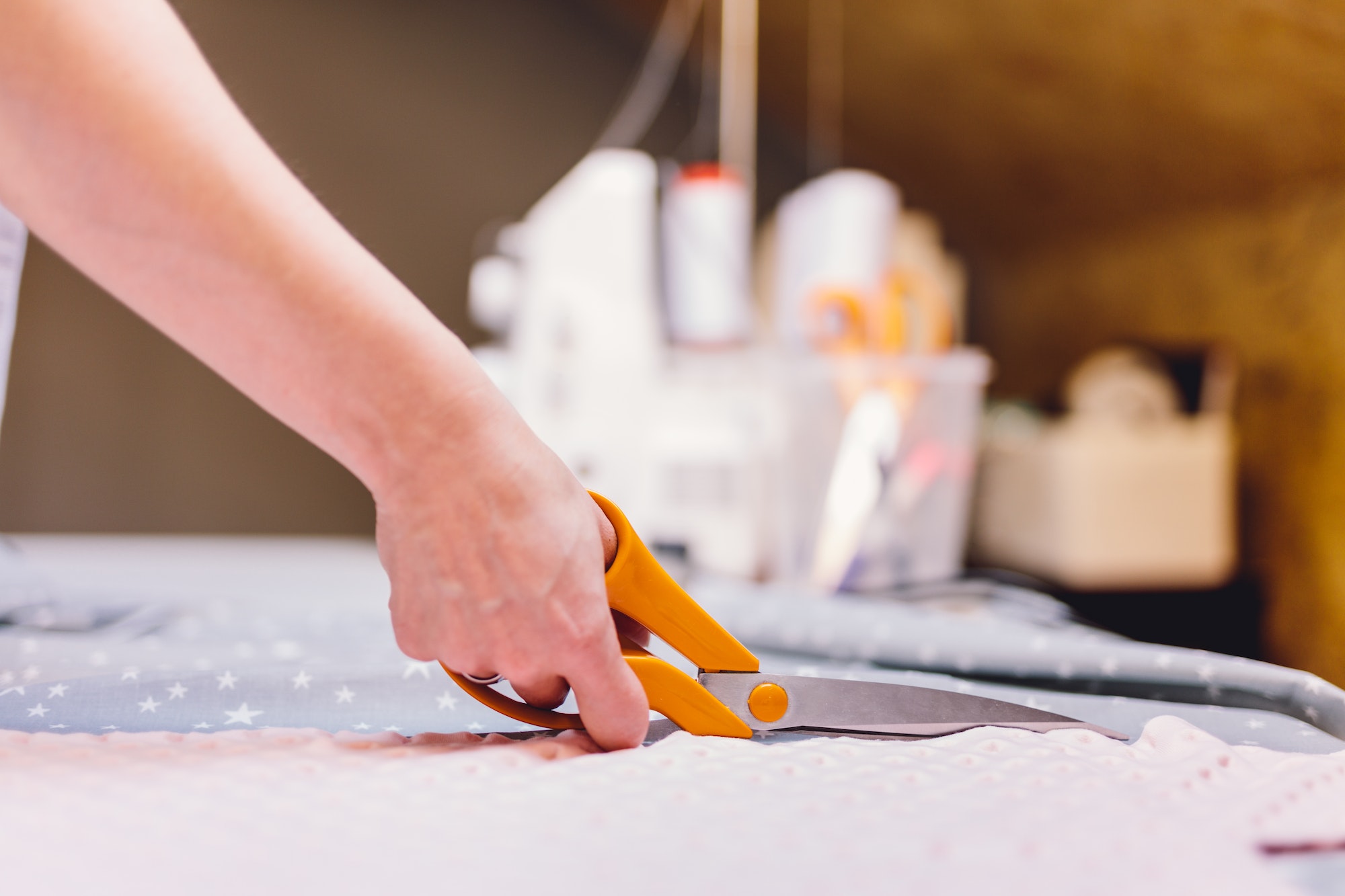 Seamstress dressmaker cutting fabric in clothes sewing workshop